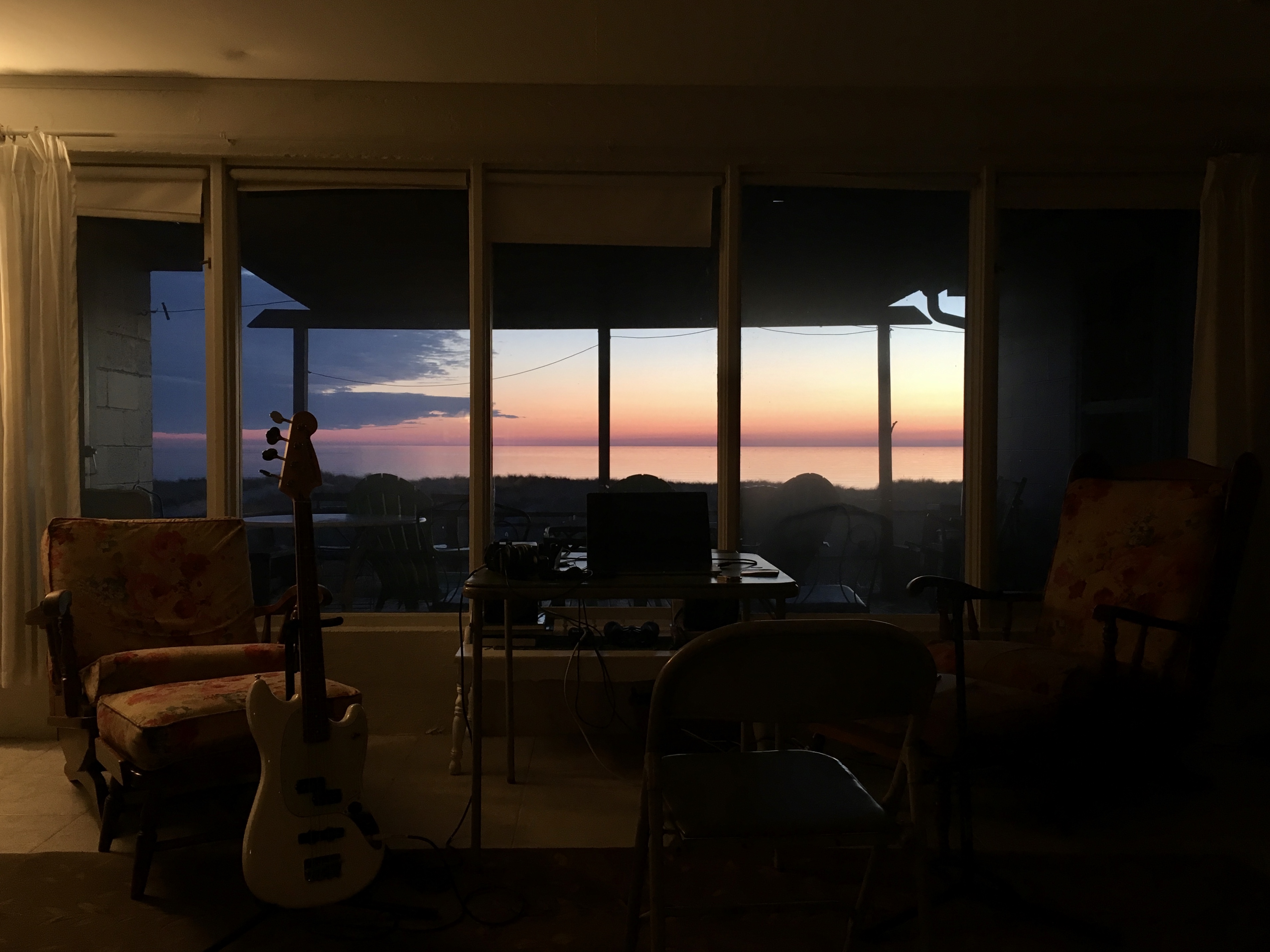 Recording equipment setup at a cottage on Lake Michigan, used by Alex Silver for the making of Five Collages (2019). View of pink, purple, and blue sunset from the living room.